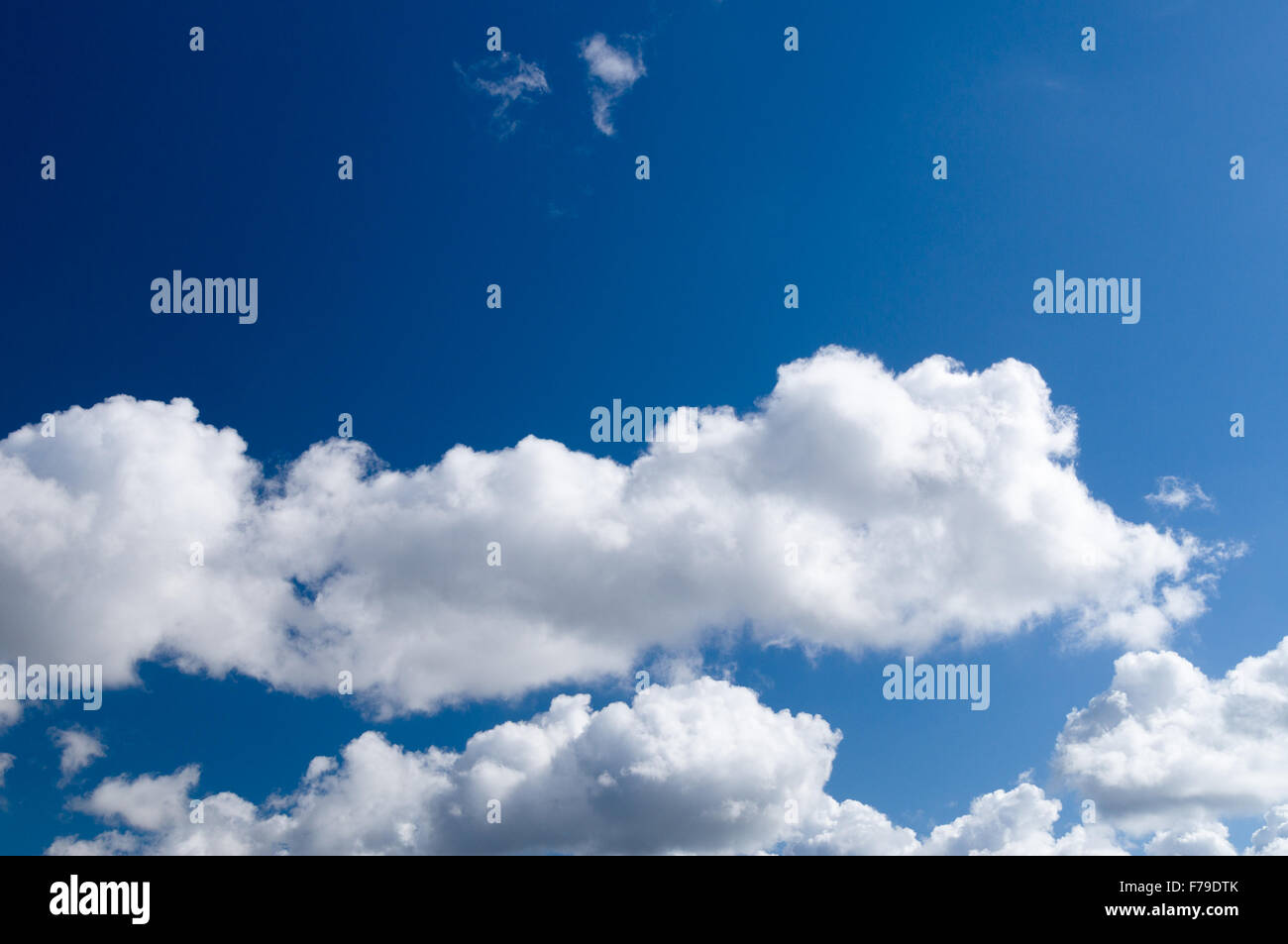 Blauer Himmelshintergrund mit flauschigen Wolken Stockfoto