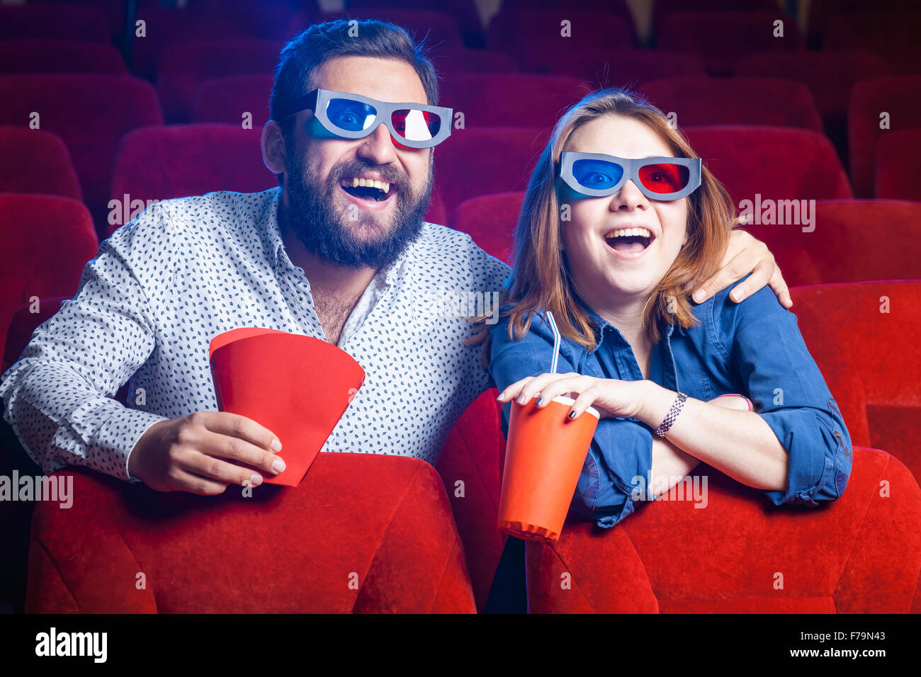 Die Zuschauer sitzen im Kino und Film mit Tassen Cola und Popcorn. Konzept einer Vielzahl von menschlichen Emotionen. Stockfoto