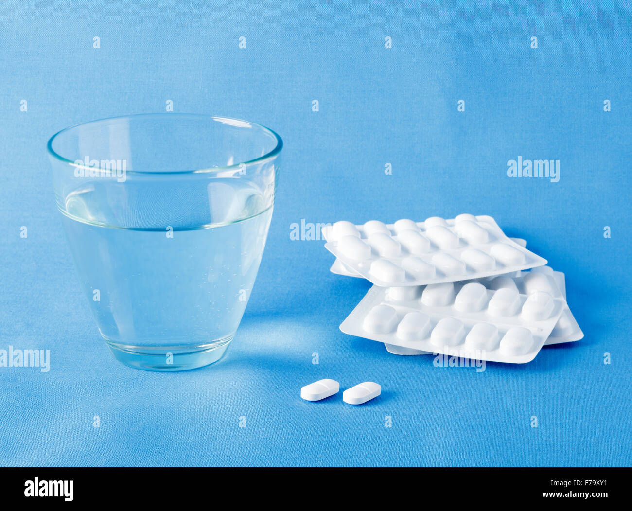 Tabletten und ein Glas Wasser Stockfoto