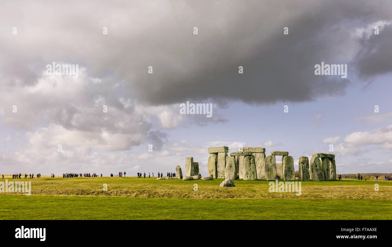 Stonehenge, prähistorische Monument gesetzt gegen die Gruppen von Besuchern und einem sonnigen blauen Himmel. Stockfoto