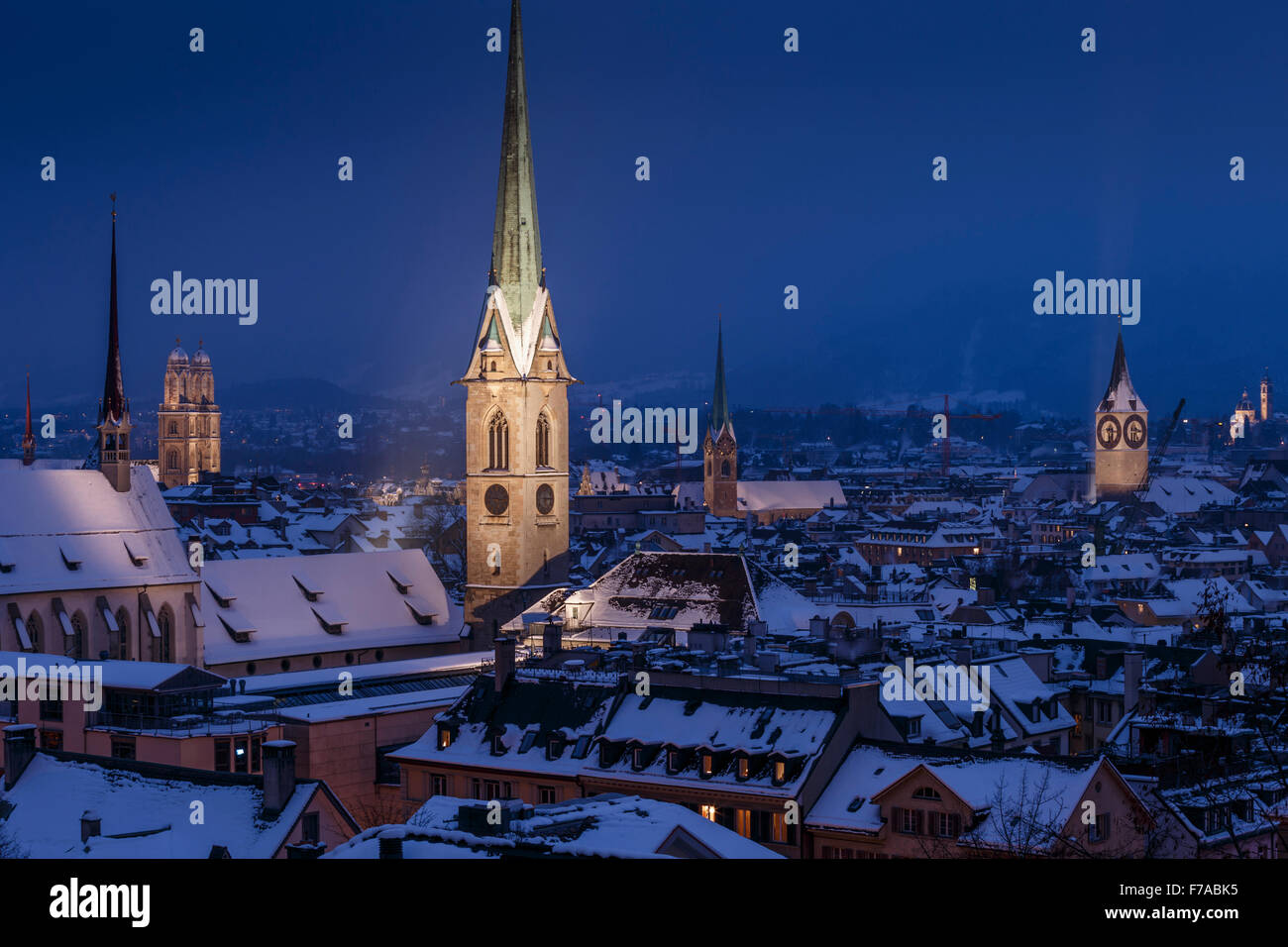Die Altstadt mit Schnee bedeckten Dächer in der Nacht mit dem beleuchteten gotischen Glockentürme, Zürich, Schweiz. Stockfoto