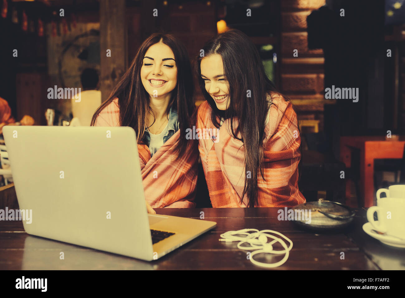zwei Mädchen beobachten etwas in laptop Stockfoto
