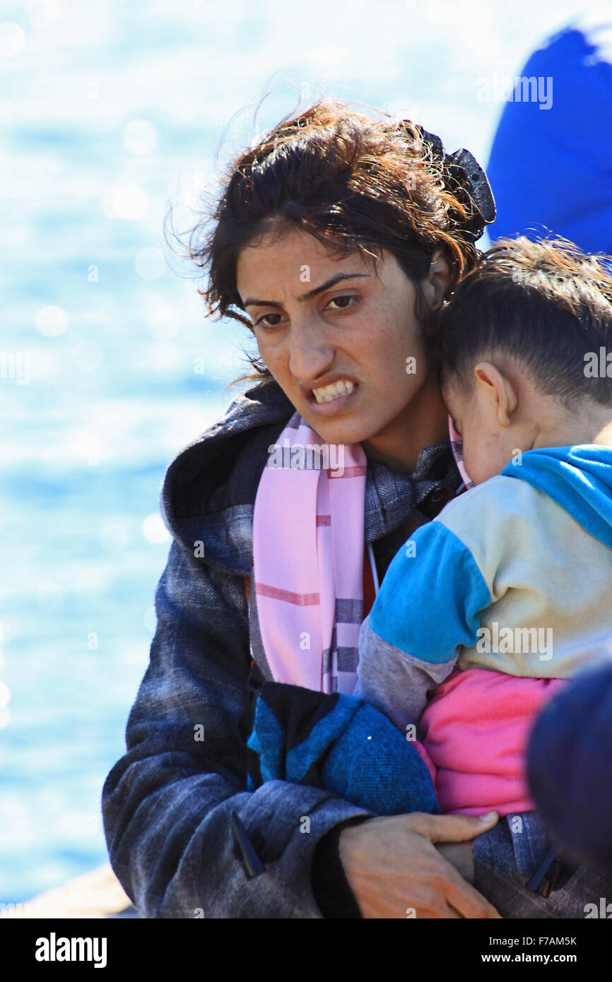 Eine syrische Flüchtlingskomitantin, die ihr kleines Kind auf Molyvos auf der Insel Lesbos Griechenland hält, nachdem sie aus dem Krieg geflohen war und Syrien mit einem aufblasbaren Boot zerrissen hatte Stockfoto