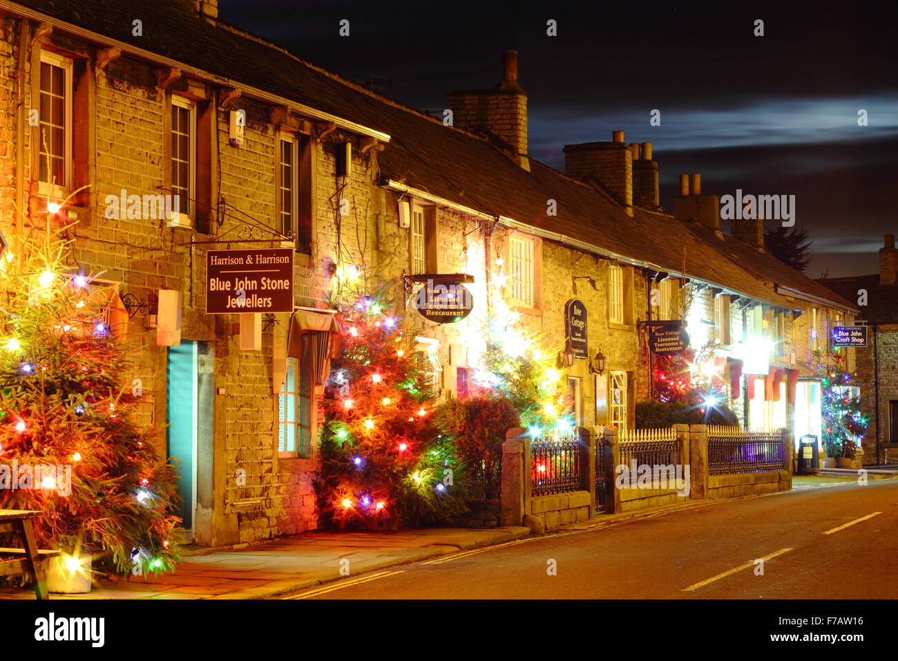 Beleuchtete Weihnachtsbäume säumen die Hauptstraße in Castleton; ein Dorf im Peak District, Derbyshire UK Stockfoto