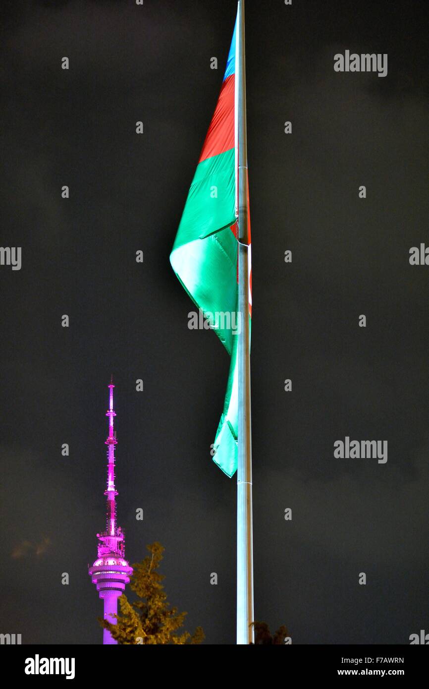 Aserbaidschanische Flagge beleuchtet in der Nacht vor dem lila beleuchteten Telekom-Turm in Baku, Hauptstadt von Aserbaidschan Stockfoto