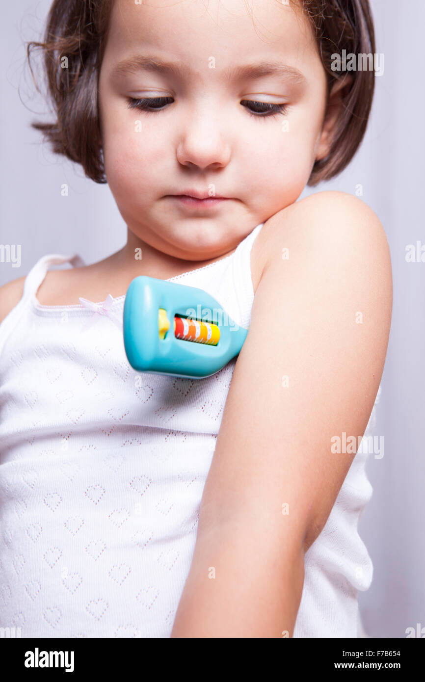 Niedliche kleine Mädchen spielen Arzt mit Spielzeug-Thermometer. Isoliert auf weißem Hintergrund Stockfoto