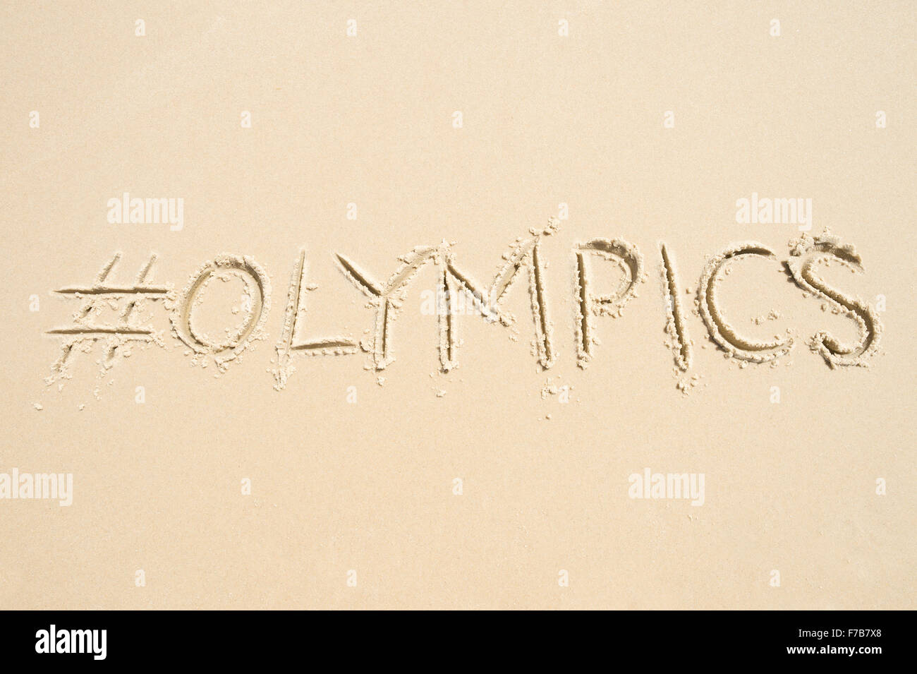 RIO DE JANEIRO, Brasilien - 10. November 2015: Handschriftliche Hashtag-social Media-Nachricht für die Olympischen Spiele im weichen Sand geschrieben. Stockfoto