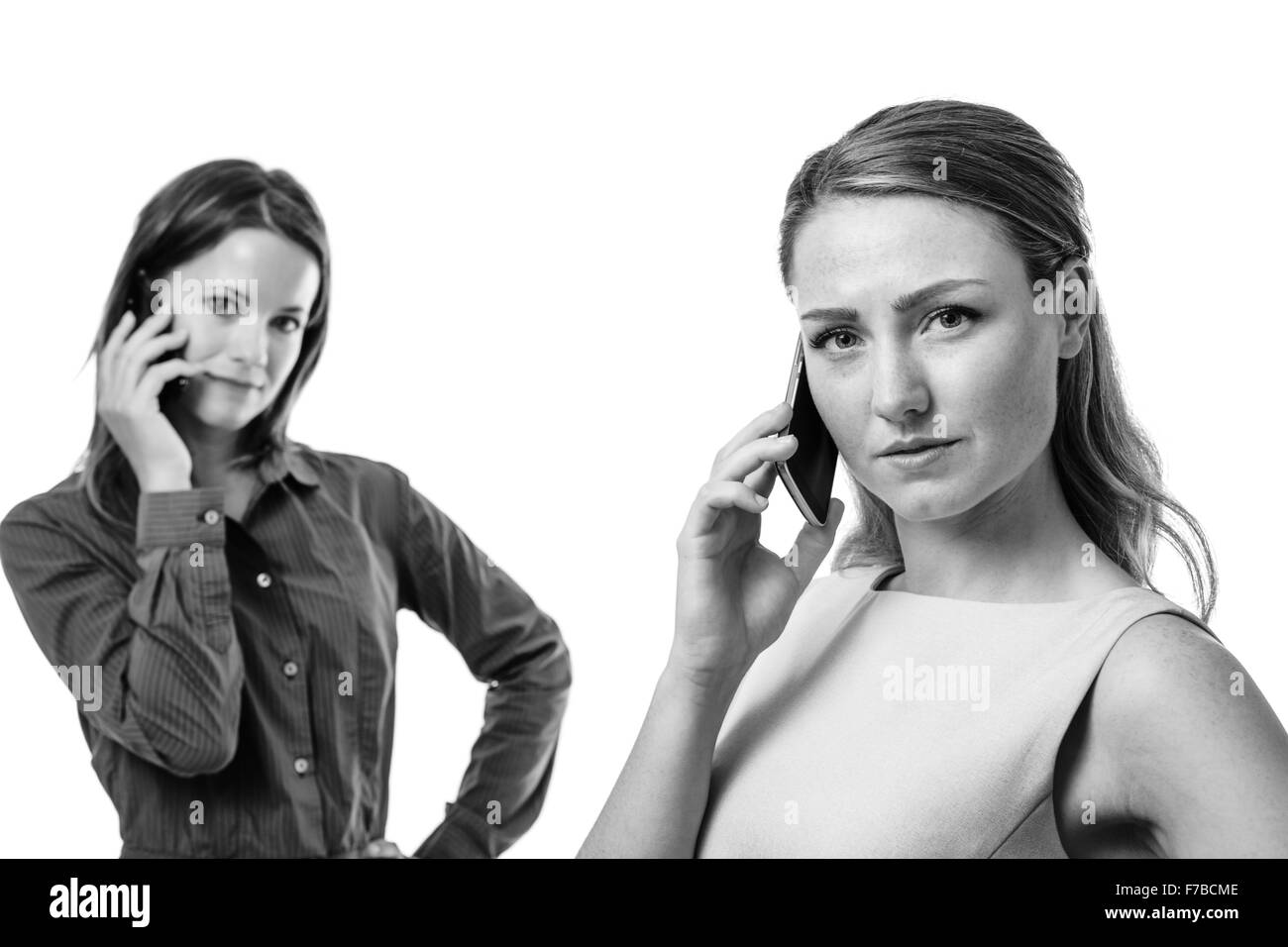 zwei Geschäftsfrauen eins vor anderen sprechen auf dem Handy Stockfoto