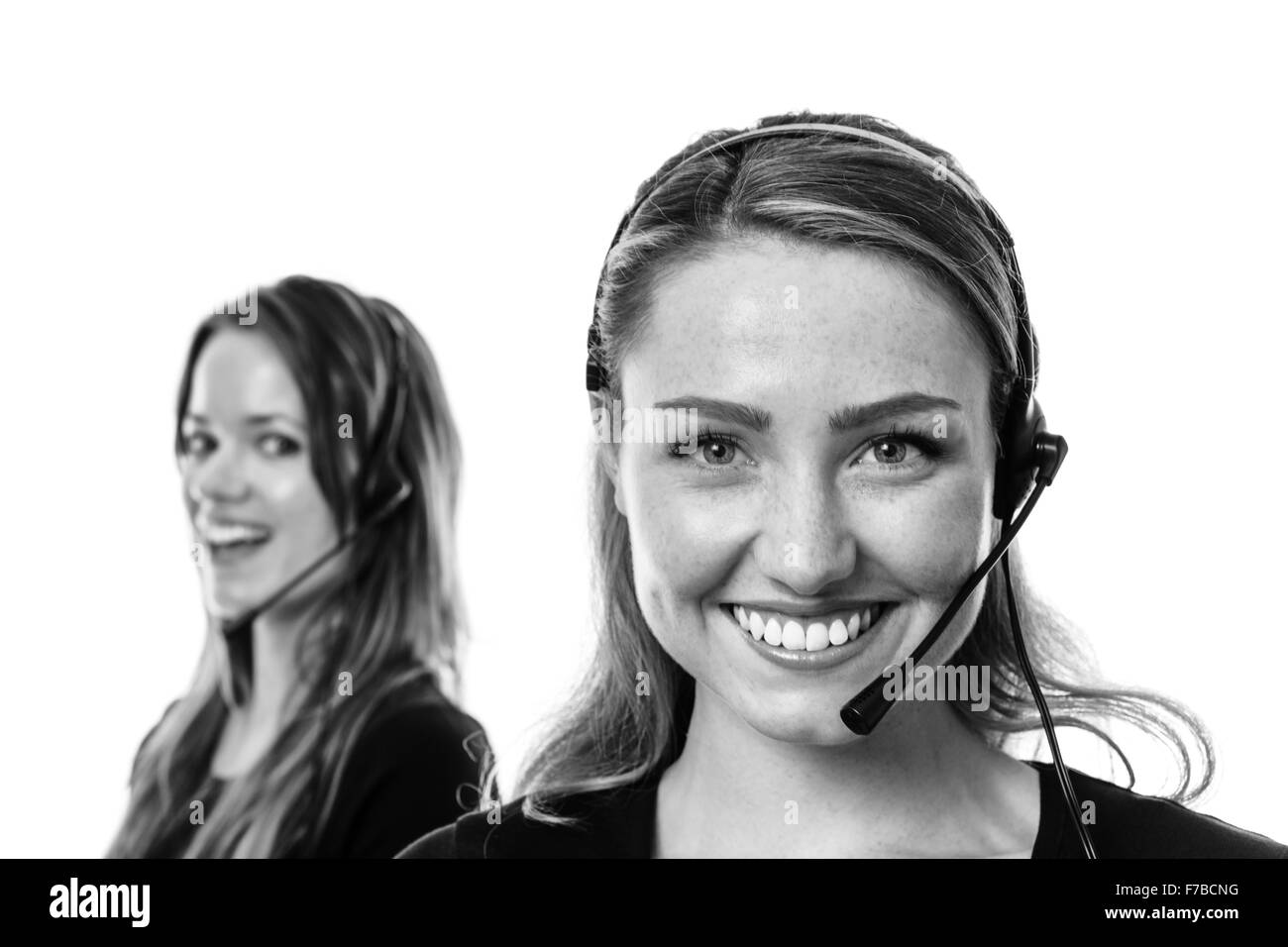 zwei Frauen eine steht vorne im Fokus tragen ein Kopfhörer im Gespräch Stockfoto