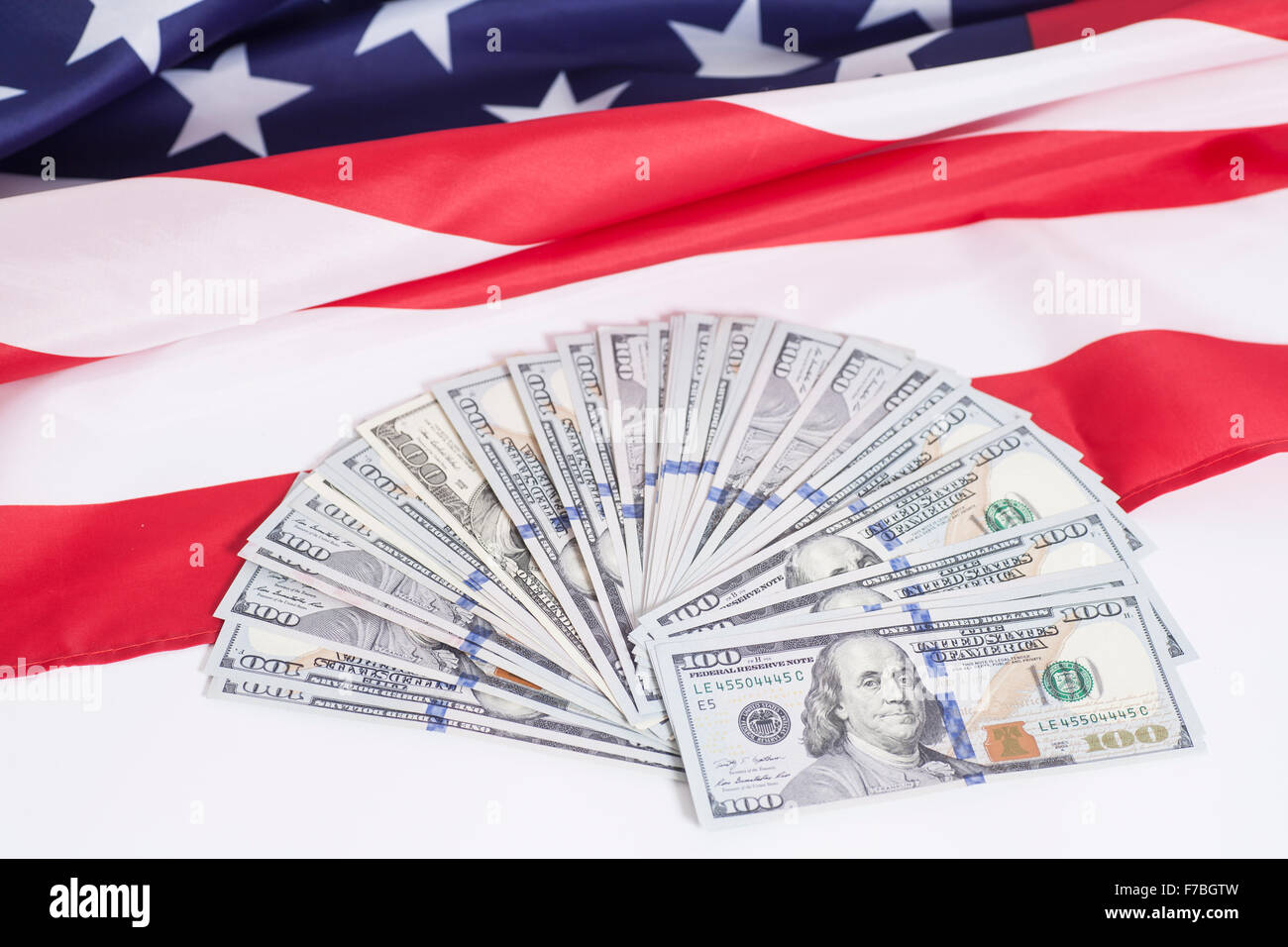 Hundert-Dollar-Scheine mit amerikanischer Flagge Hintergrund Stockfoto