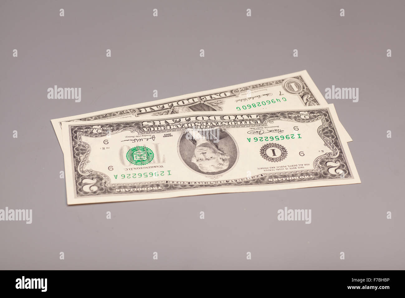 Amerikanische ein bis zwei Dollar Geldscheine auf grau Stockfoto