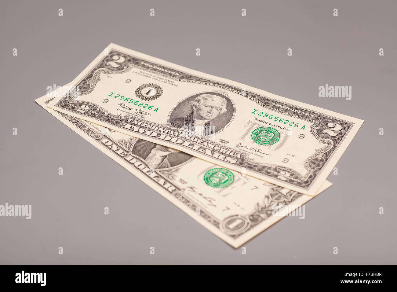 Amerikanische ein bis zwei Dollar Geldscheine auf grau Stockfoto
