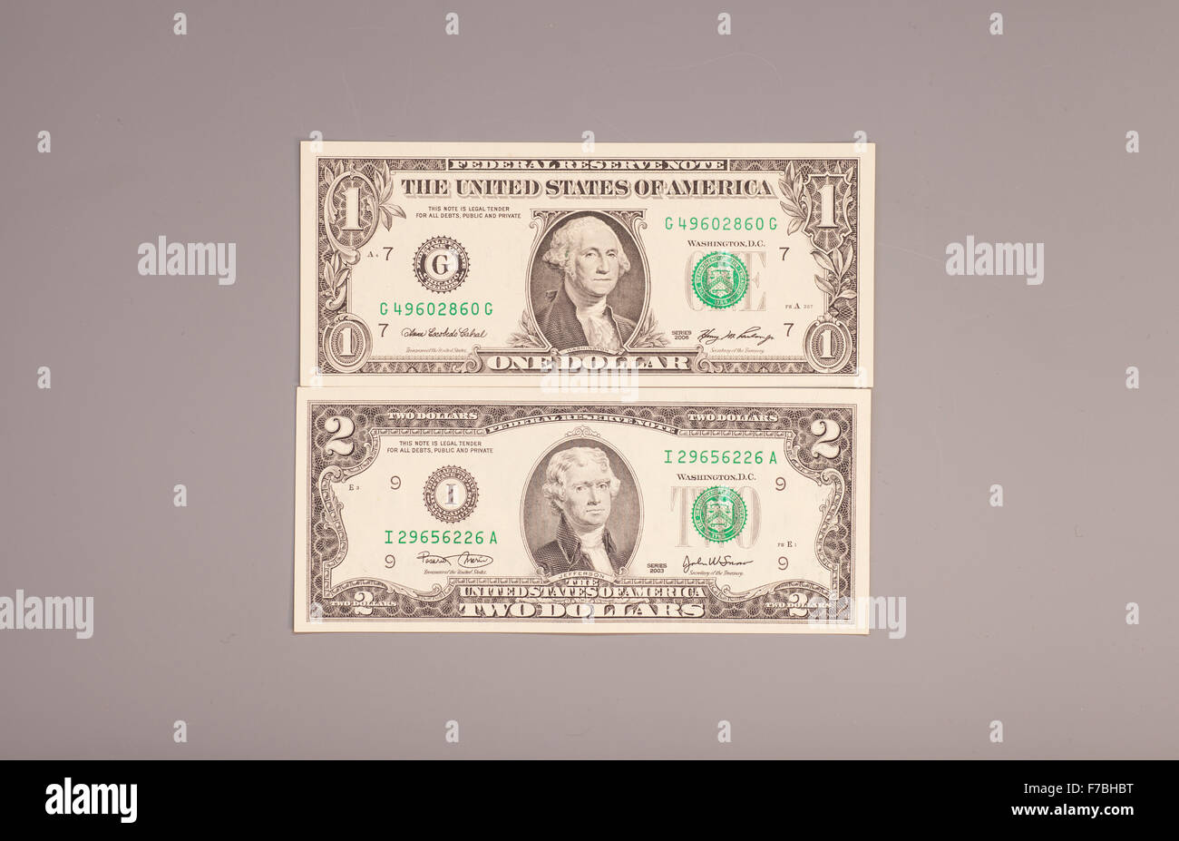 Amerikanische ein bis zwei Dollar Geldscheine auf grau Stockfoto