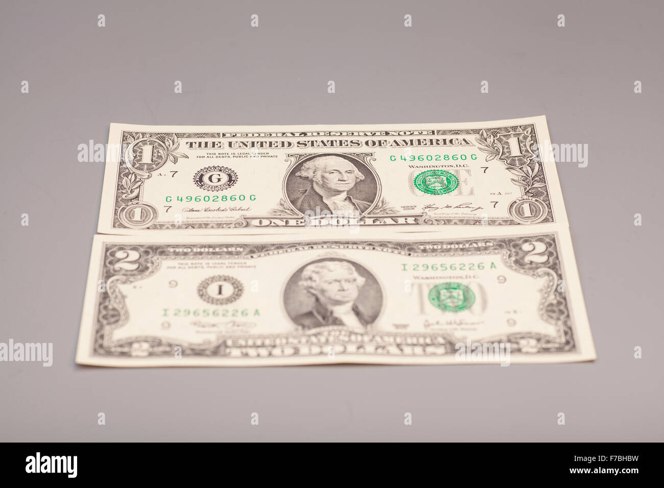 Amerikanische ein bis zwei Dollar Geldscheine auf grau Stockfoto