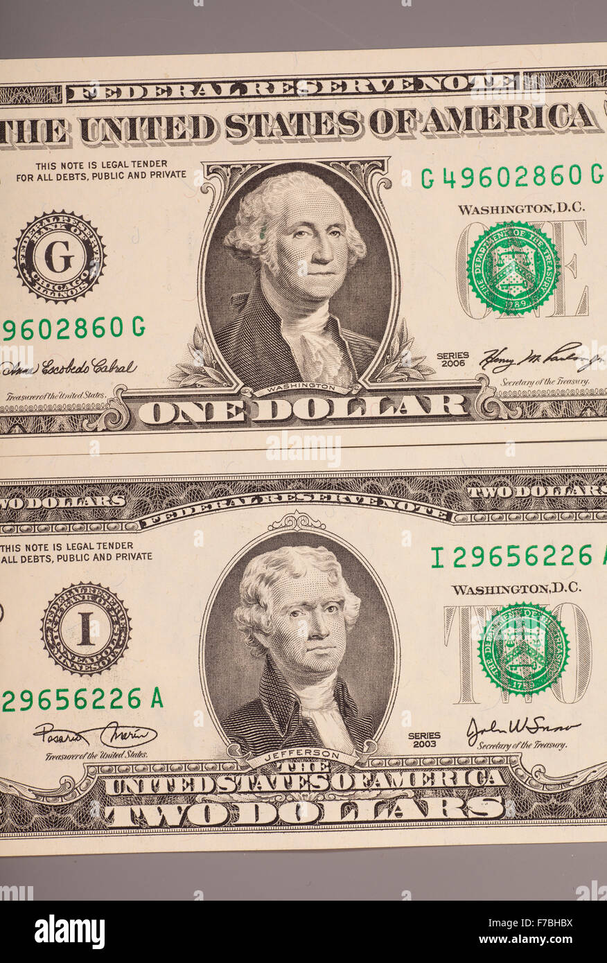 Amerikanische ein bis zwei Dollar Geldscheine auf grau Stockfoto