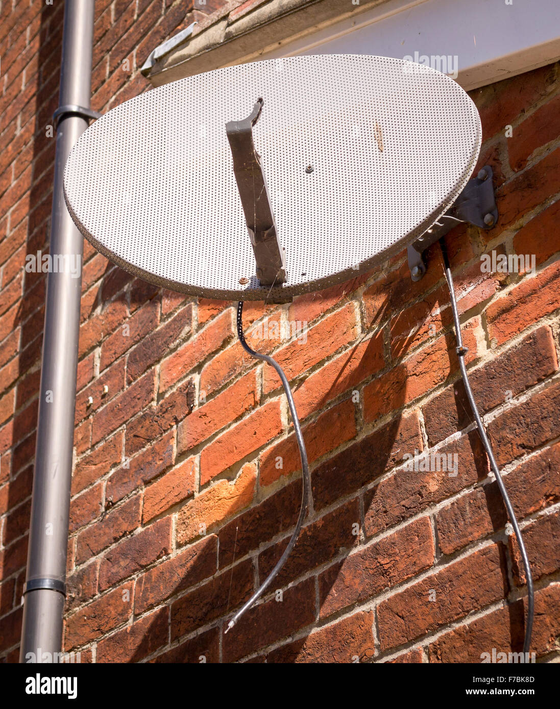 Defekte TV-Satellitenschüssel auf Seite des Hauses Stockfoto