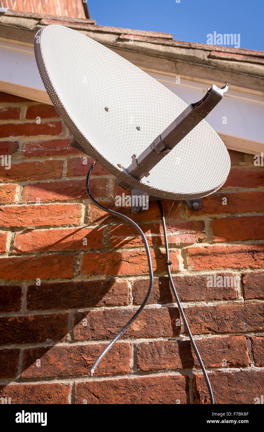 Defekte TV-Satellitenschüssel auf Seite des Hauses Stockfoto
