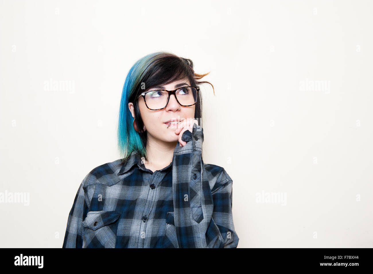 Hübsche junge alternative Teen Frau mit Brille nachschlagen und lächelnd Stockfoto
