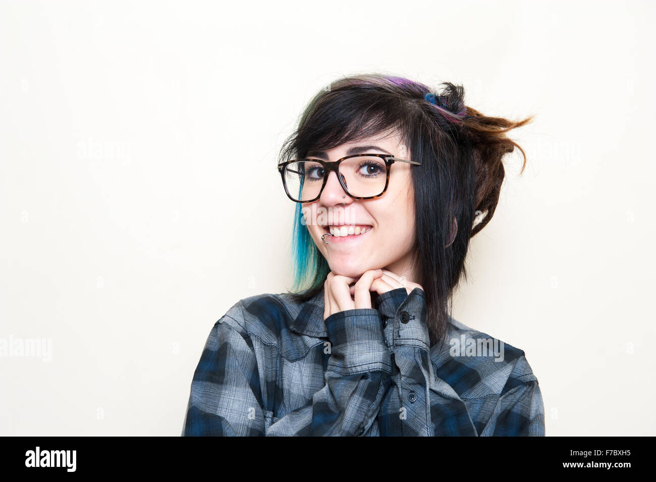 Hübsche junge alternative Teen Frau mit Brille posiert lächelnd Stockfoto