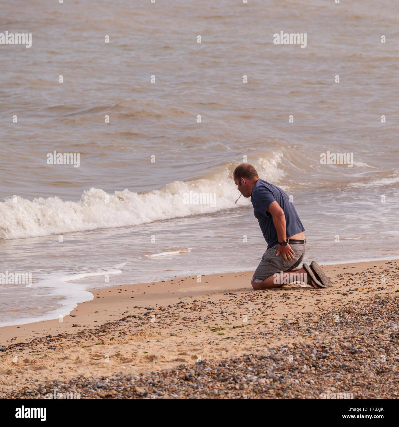 Ein Mann schreiben in den Sand am Strand in Southwold, Suffolk, England, Großbritannien, Uk Stockfoto