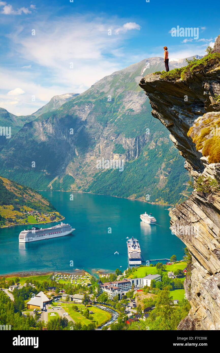 Touristen, die auf den Felsen stehen Kreuzfahrtschiffe im Hintergrund, Geiranger Fjord, Norwegen Stockfoto