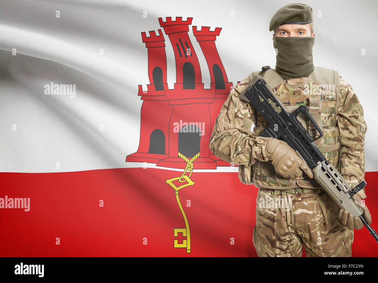 Soldat mit Maschinengewehr mit Nationalflagge auf Hintergrund - Gibraltar Stockfoto