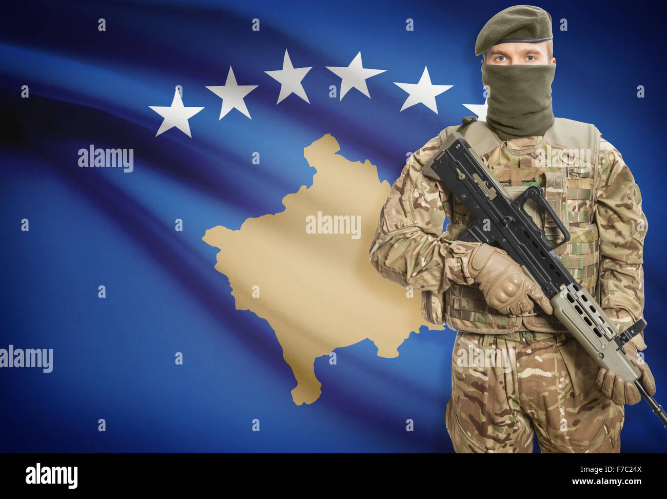 Soldat mit Maschinengewehr mit Nationalflagge auf Hintergrund - Kosovo Stockfoto
