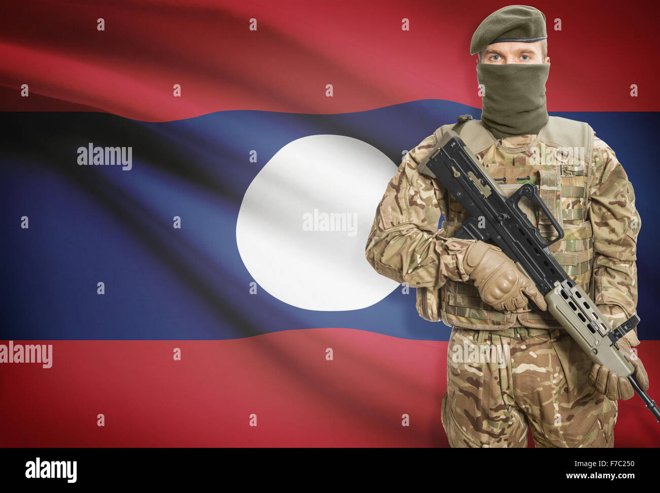 Soldat mit Maschinengewehr mit Nationalflagge auf Hintergrund - Laos Stockfoto