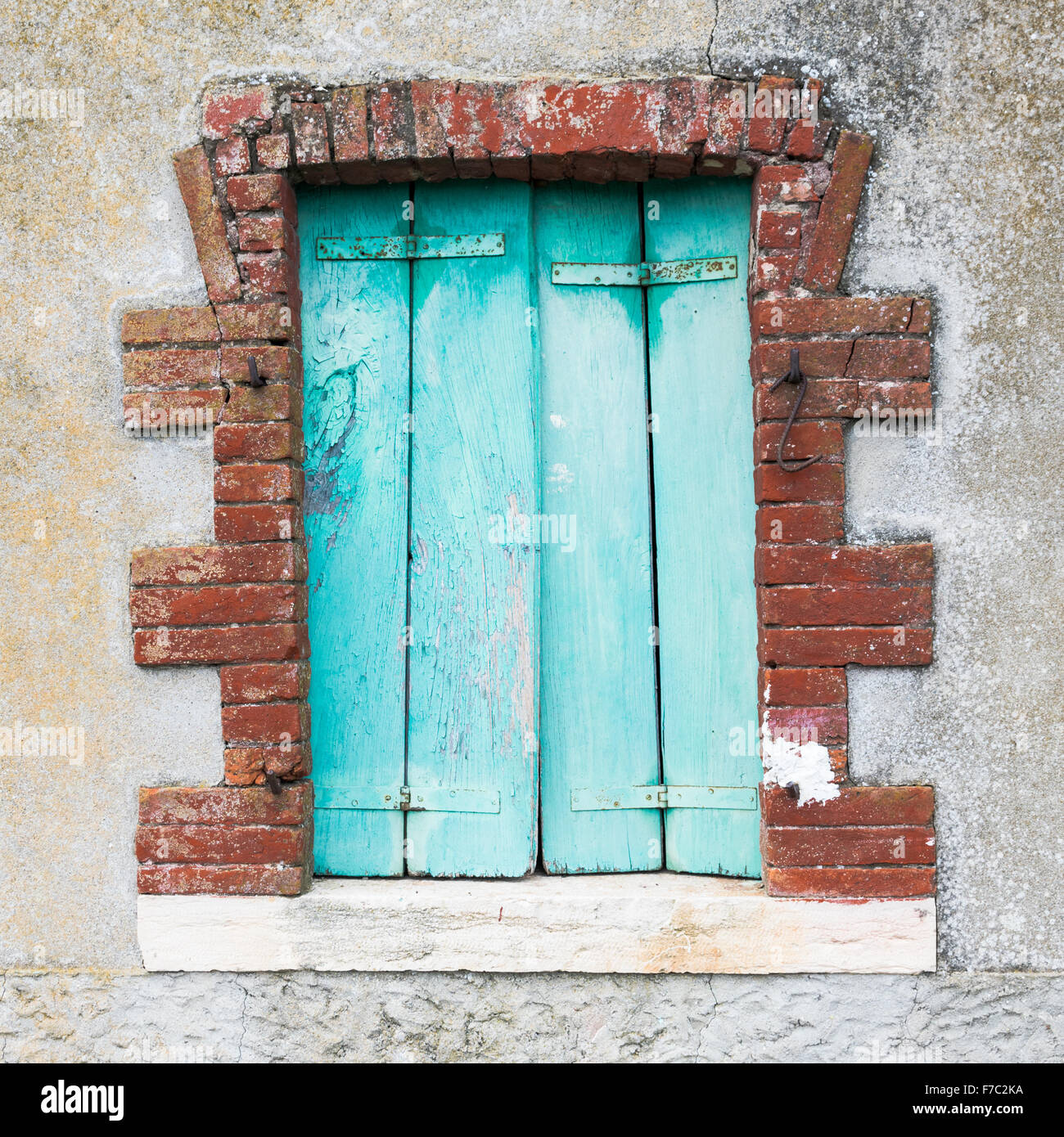 Fenster eines Bauernhauses mit Holzbalkonen und rotem Backstein Rahmen. Stockfoto