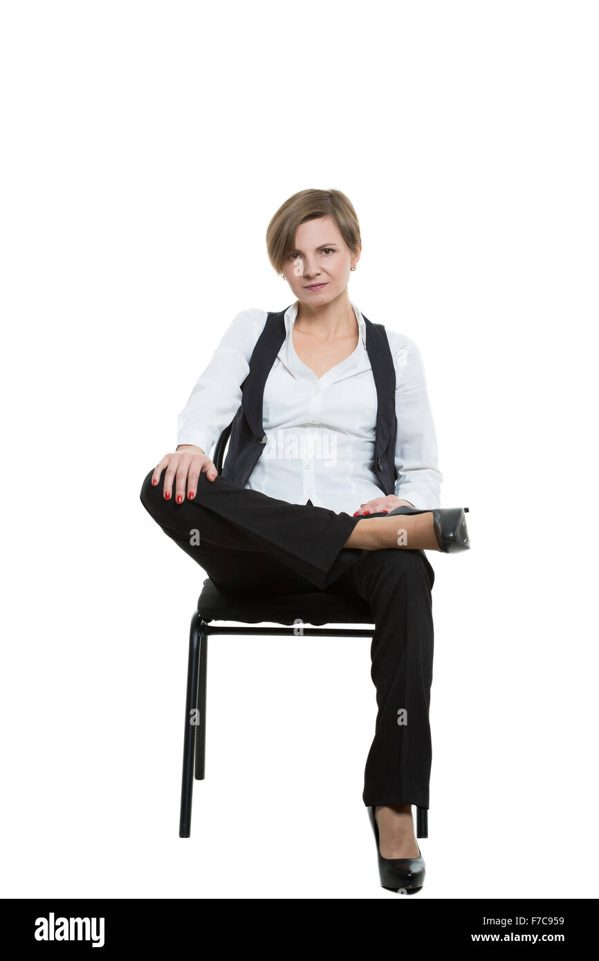 Frau sitzt in einem Stuhl. Beine gekreuzt, fester Arm. verfehlt.  beherrschende Stellung. Isoliert auf weißem Hintergrund Stockfotografie -  Alamy