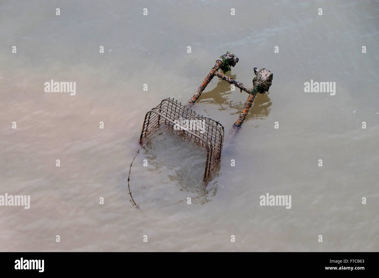 Warenkorb im Wasser am Dockside verworfen. Stockfoto