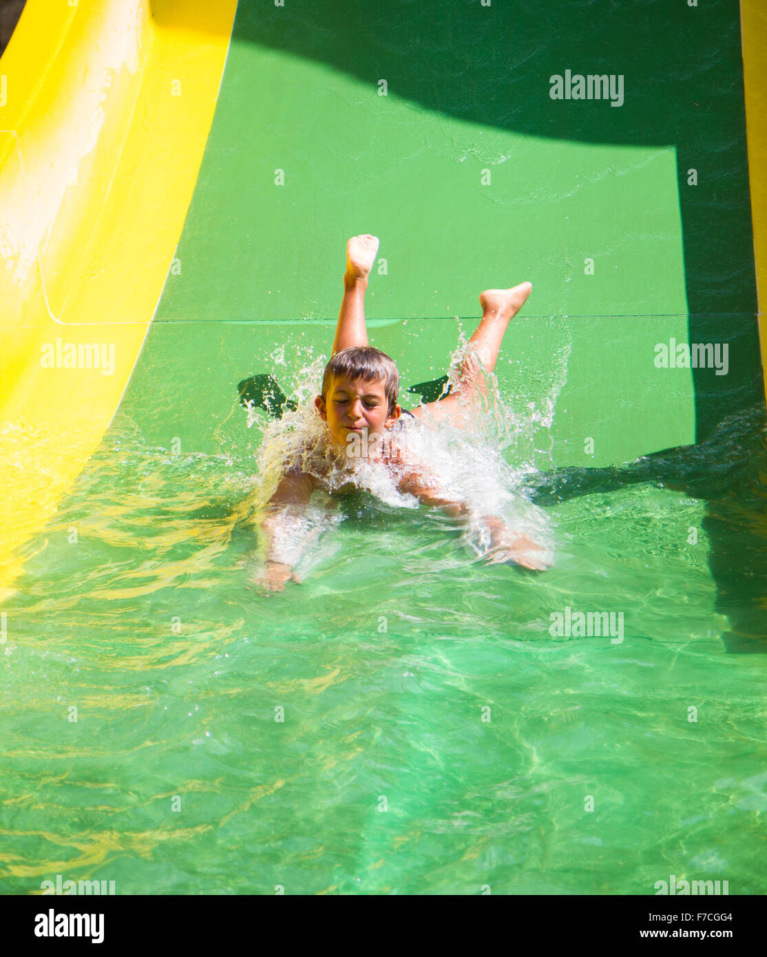 Kind spielt auf Wasserrutsche im Freizeitpark Stockfoto