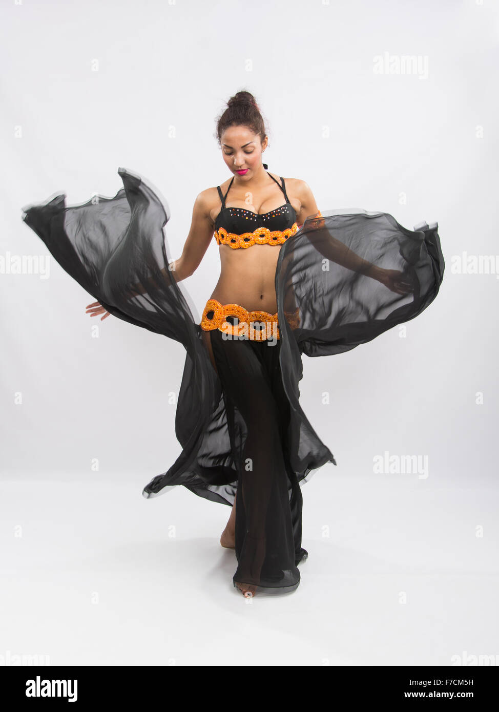 Junges Mädchen Mulatte tanzen in einem langen schwarzen ehrliche offene Kleid ist auf einem hellen Hintergrund isoliert Stockfoto