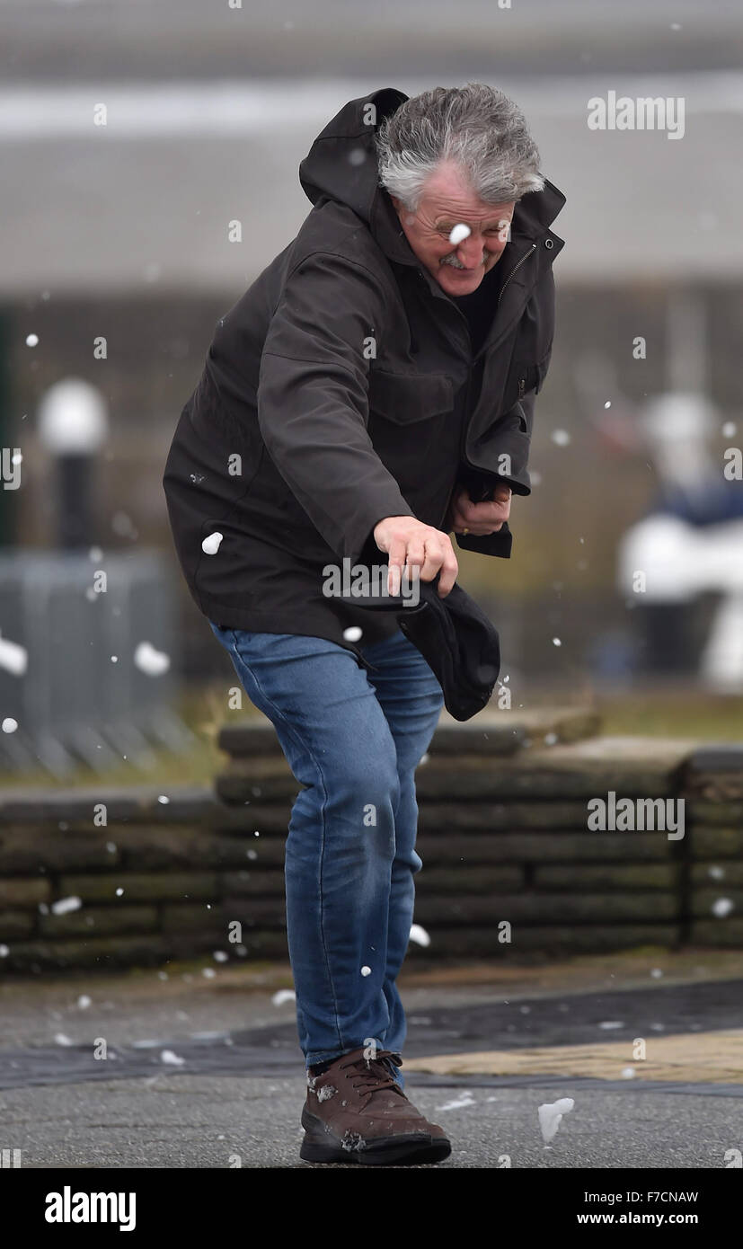 Ein Mann verliert fast seinen Hut bei starkem Wind verursacht durch Sturm Clodagh in Porthcawl Seafront, South Wales, UK. Stockfoto