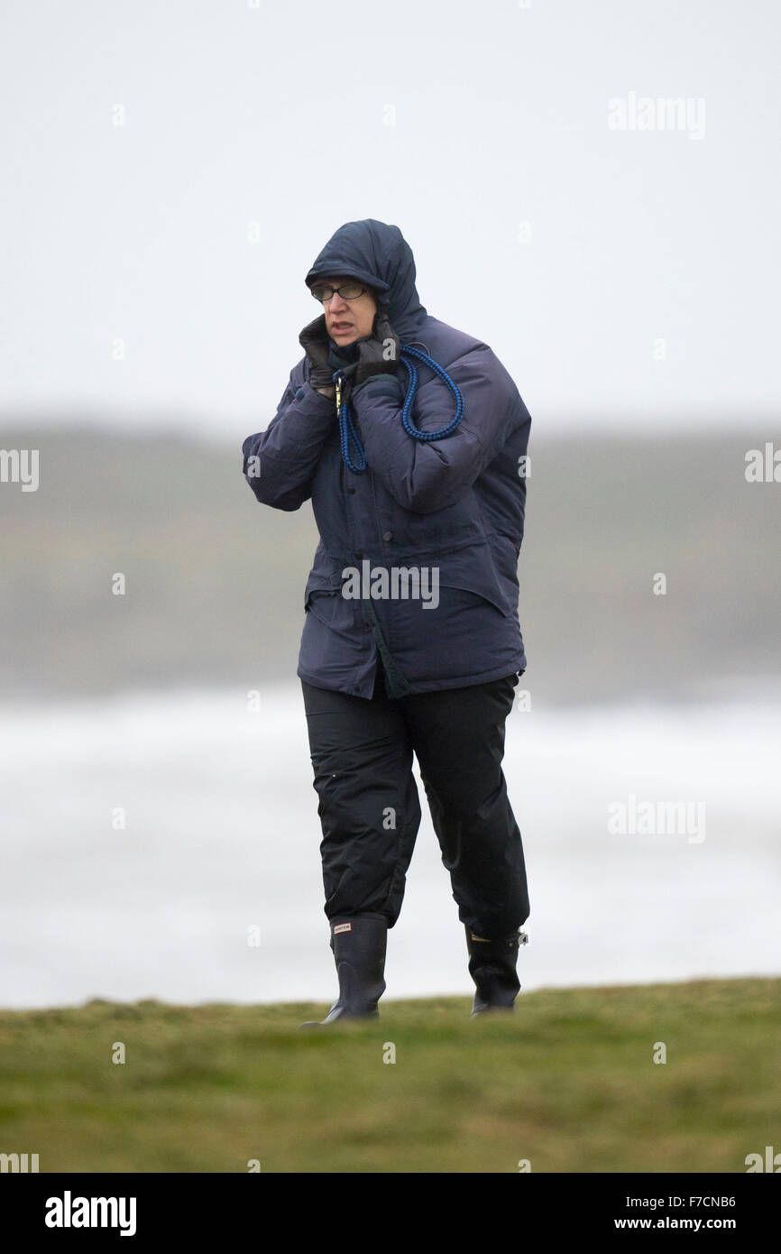 Eine Walker ist bei Sturm Clodagh in Porthcawl Seafront, South Wales bei starkem Wind geblasen. Stockfoto