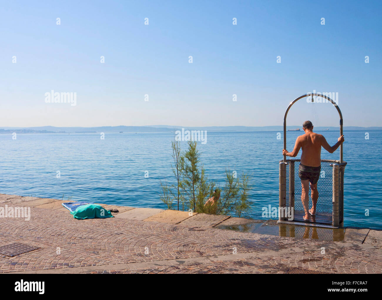 Triest, Italien, Mann unter der Dusche in Barcola Promenade und kostenloses Baden Strang, beliebte Sommer-Spot der Stadt Stockfoto