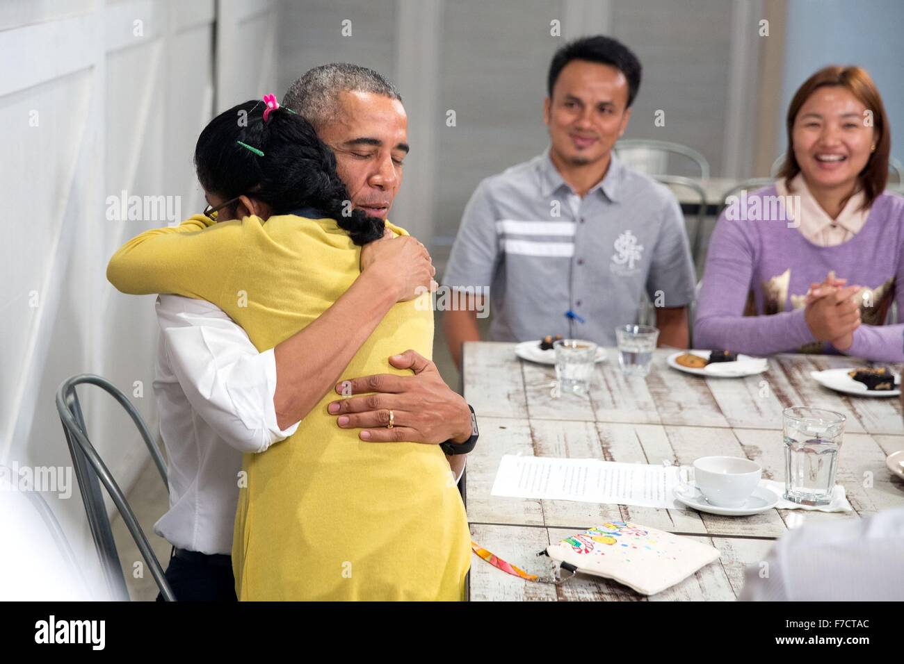 US-Präsident Barack Obama ist ein junges Mädchen bei einem Rundgang durch die würde für Children Foundation 21. November 2015 in Kuala Lumpur, Malaysia umarmte. Das Zentrum unterstützt Arme Familien und Flüchtlingen, darunter die von Myanmar und Syrien. Stockfoto