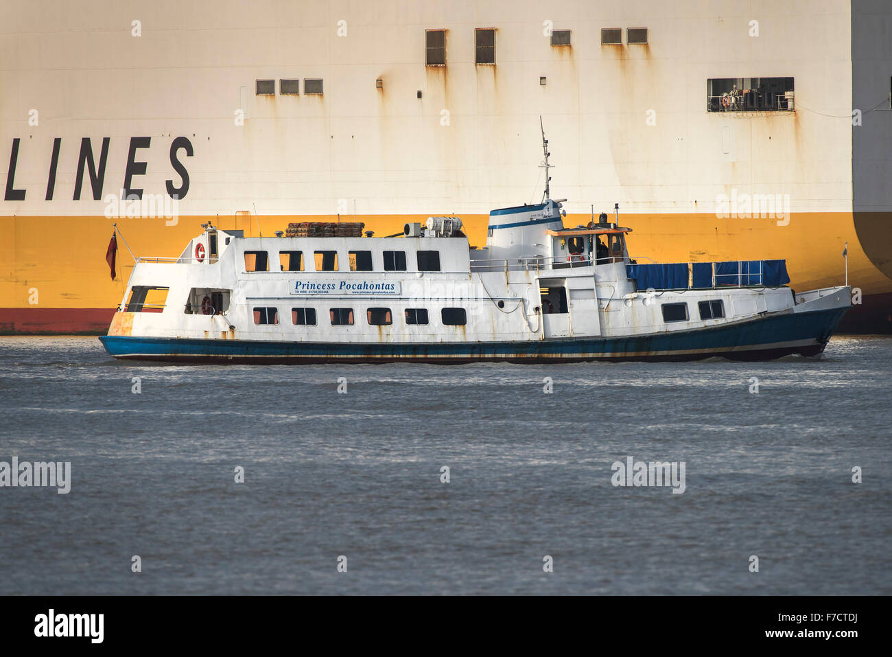 Die Fähre Prinzessin Pocahontas ist durch Grande Kongo-Containerschiff auf der Themse in den Schatten gestellt. Stockfoto