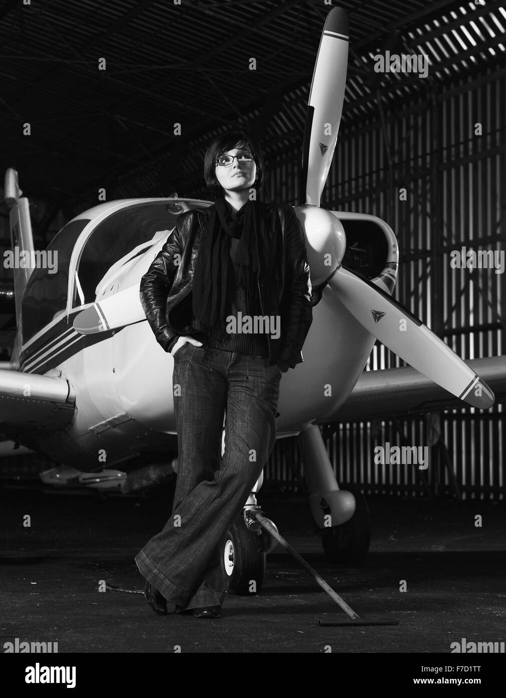 schöne junge Frau Modell in modischer Kleidung posieren vor altes private Flugzeug Stockfoto