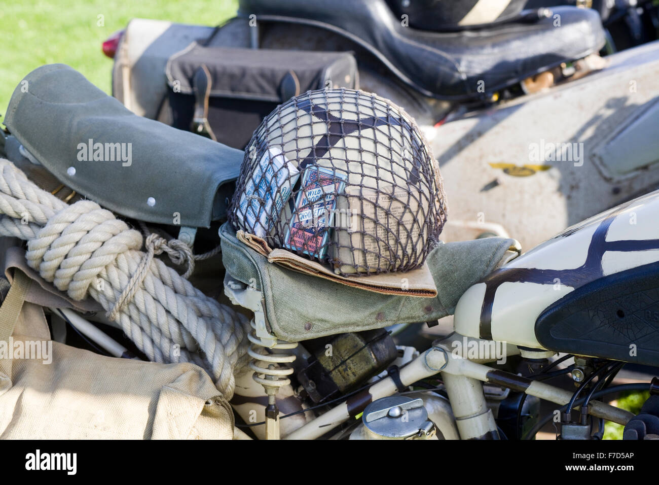 Militärische Motorrad und Helm mit Spielkarten und Zigaretten im Netz Stockfoto