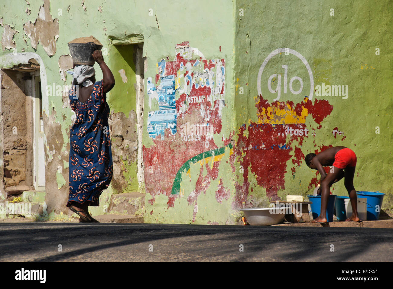 Frau mit Sand, junge, die Wäsche draußen bunte Hause, Elmina, Ghana Stockfoto