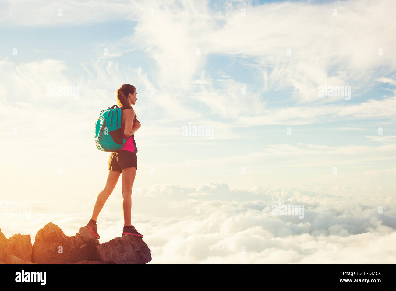 Frau, Wandern in den Bergen über den Wolken bei Sonnenuntergang, Abenteuer im freien aktiven Lebensstil Stockfoto