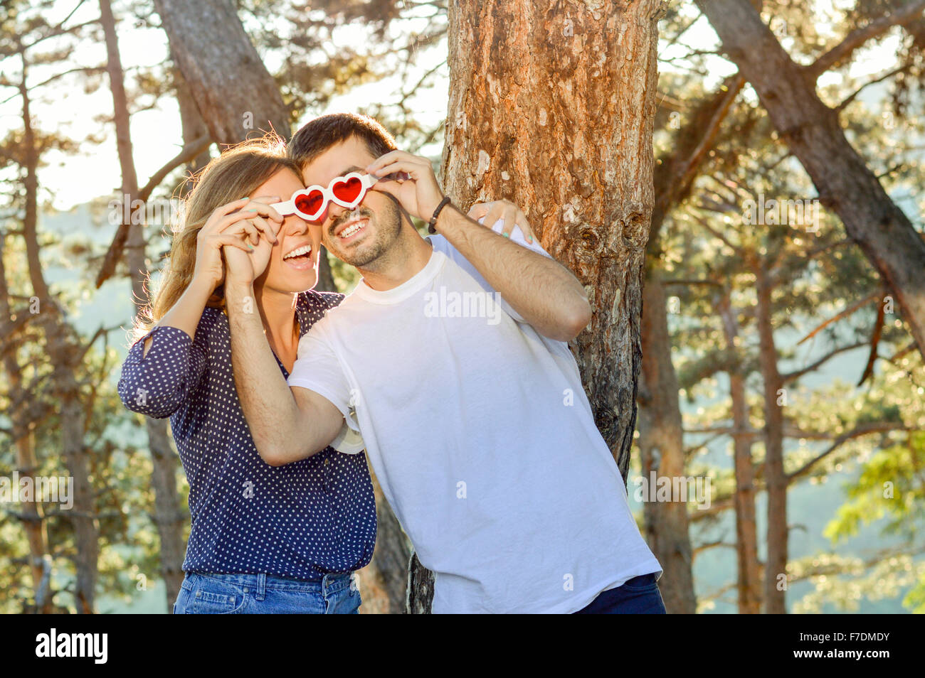Glückliches Paar im Park suchen werfen herzförmige Brille Stockfoto