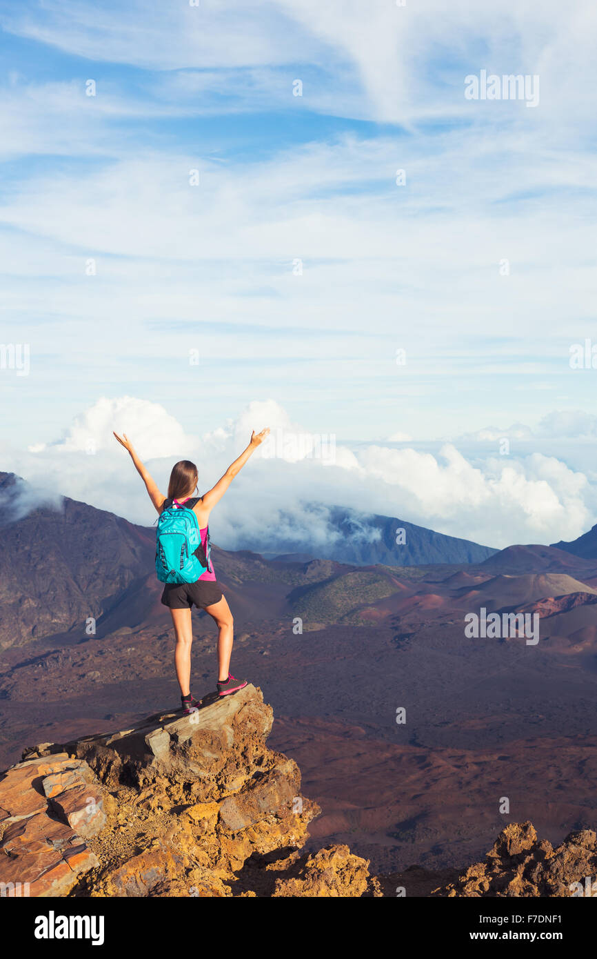 Junge Frau glücklich Wanderer mit Rucksack stehend auf Berggipfel mit offenen Armen Stockfoto