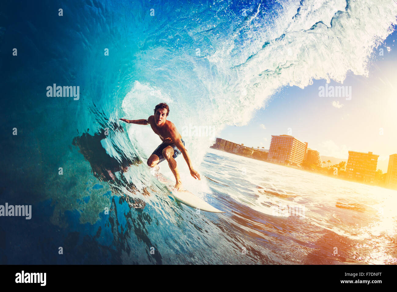 Surfer am Blue Ocean Wave immer bei Sonnenaufgang Barreled Stockfoto