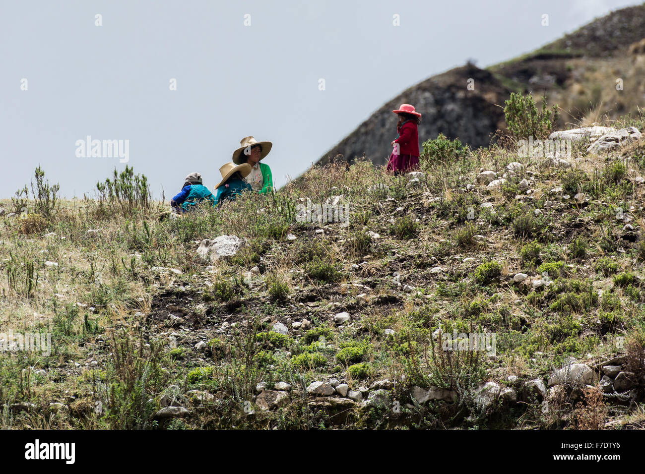 Peruanische Frau und kleinen Kindern sitzen auf Hügel in typischer Kleidung der Bergregion von Cajamarca Stockfoto