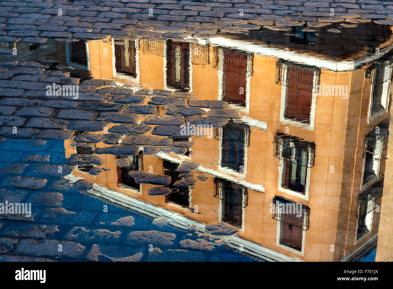 Wohnungen-Gebäude spiegelt sich in einer Pfütze in der Plaza De La Villa, Madrid de Los Austrias, Madrid, Spanien. Stockfoto