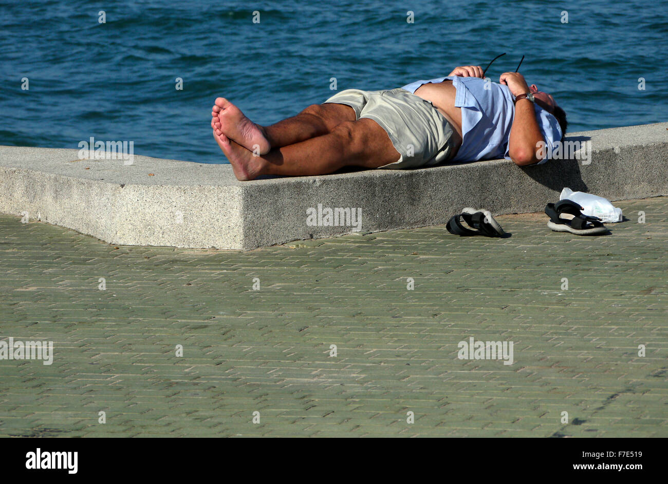 Halb bekleidet Männer mittleren Alters in der Sonne auf einem Meer Wand- und Gehweg in Pattaya Thailand Stockfoto