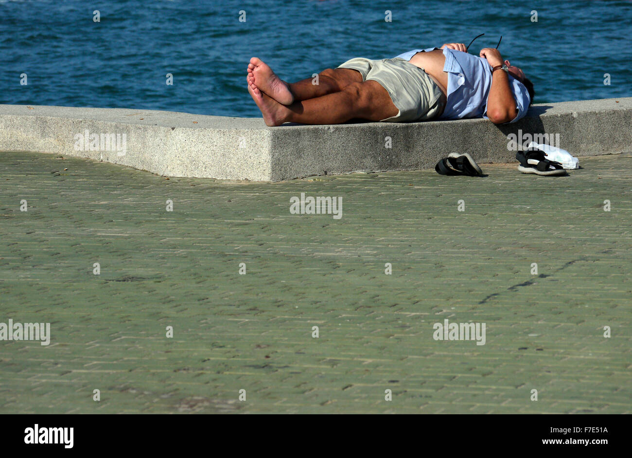 Halb bekleidet Männer mittleren Alters in der Sonne auf einem Meer Wand- und Gehweg in Pattaya Thailand Stockfoto