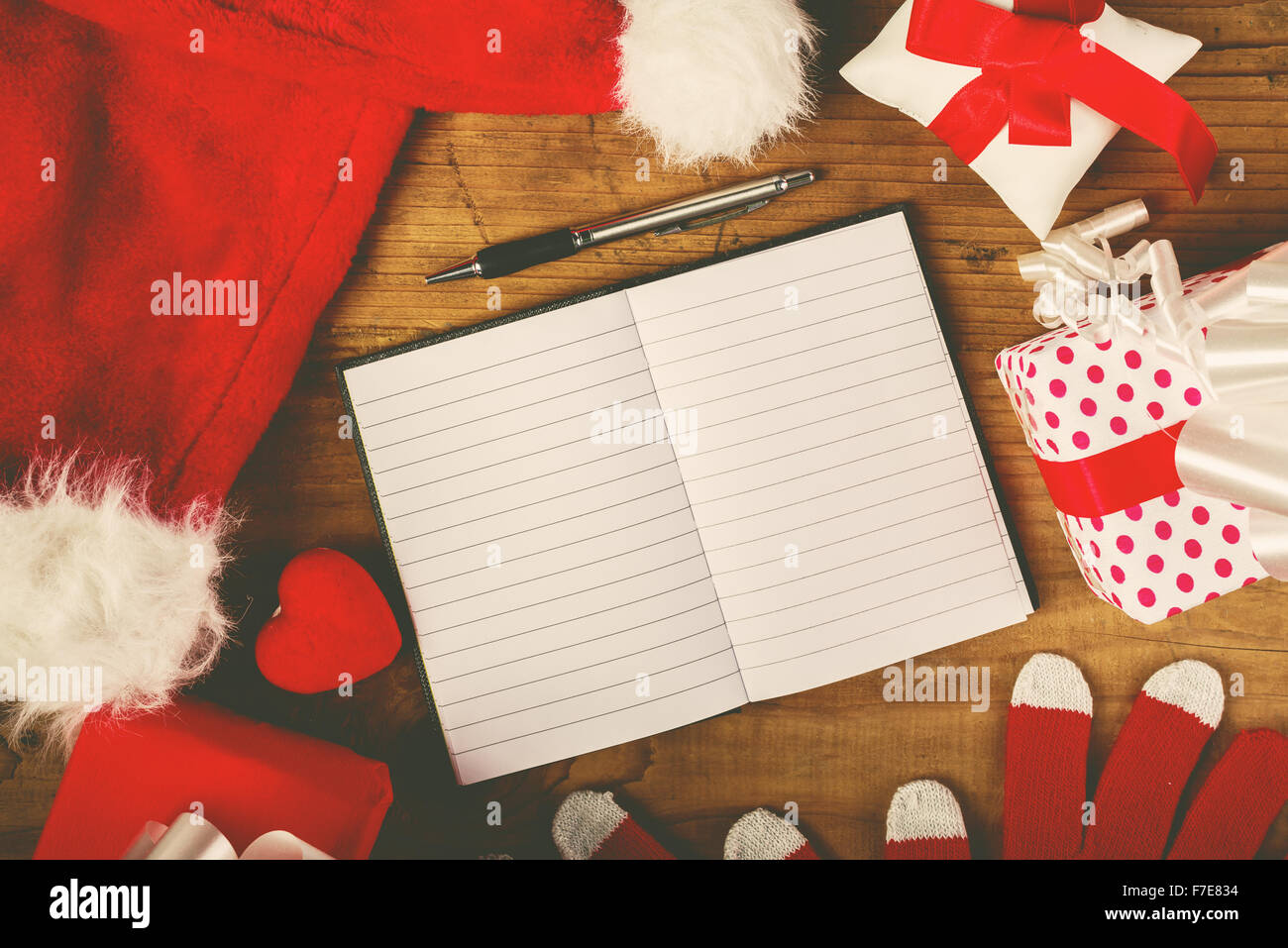 Santa Claus Schreibtisch, leeren Notizbuch als Kopie Raum für gute Kinder-Wunschliste, Mütze und Handschuhe mit Weihnachtsgeschenken und präsentieren Stockfoto